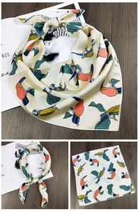 Detail eines Satin-Halstuchs mit buntem Tukan- und Blättermuster auf beigem Stoff