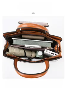 Intérieur spacieux d'un sac marron à motif croco, idéal pour tablette et objets divers