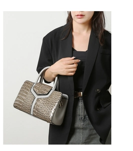 Détail macro de la texture crocodile et du design en Y sur le sac à main gris chic