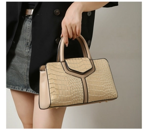 Détail du sac à main beige gaufré crocodile avec panneau en Y et poignée ronde