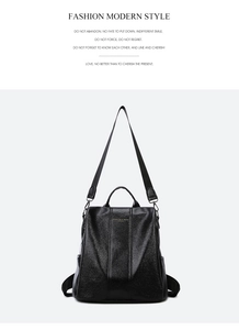 Detail of a black glossy leather backpack with gold logo and wide shoulder straps