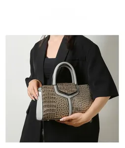 Vue détaillée du sac à main en cuir crocodile avec fermoir métallique en forme de Y
