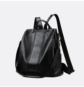 Close-up of black oily faux leather backpack featuring golden text and zipper detail