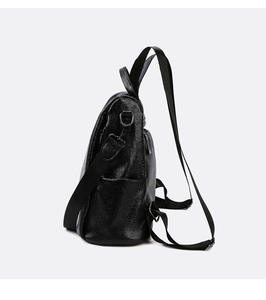Detail of black lychee grain leather backpack with wide fabric strap and side pocket
