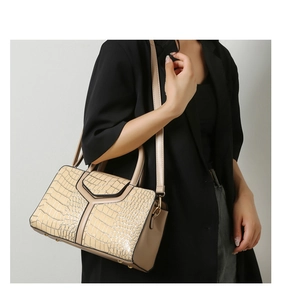 Détail du sac à main beige embossé crocodile avec surpiqûres en Y et finitions dorées