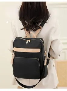 Détail du sac à dos en nylon avec garniture contrastée et fermetures éclair dorées
