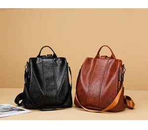 Close-up of black and brown PU leather backpacks featuring side zippers and adjustable straps