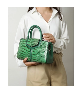 Détail du sac à main vert foncé motif crocodile avec lignes en V et doubles anses robustes