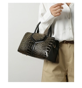Détail du sac en cuir noir avec texture crocodile dorée et motif en forme de Y élégant