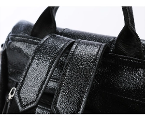Detail of glossy black backpack with crackle texture PU leather and reinforced straps