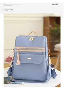 Détail d'un sac à dos en toile bleue avec pompon et fermeture éclair dorée élégante