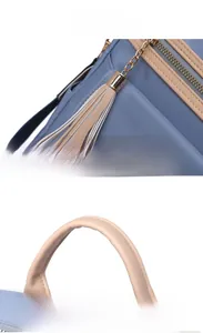 Détail du sac à dos en nylon bleu avec poignée en cuir beige et gland de fermeture doré