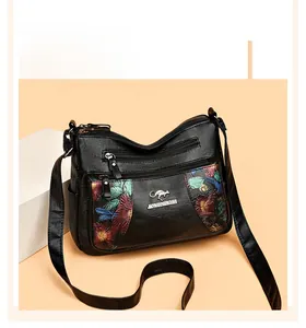 Detail view of black litchi grain leather bag with vintage floral prints and triple zippers