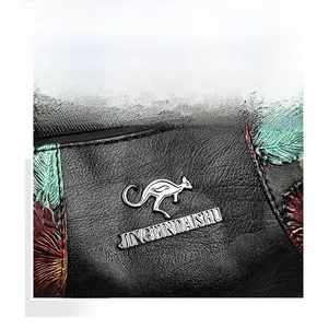 Detail of black leather texture with 3D floral pattern and golden kangaroo logo