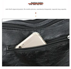 Close-up of black litchi leather bag showing functional rear anti-theft zipper pocket with phone