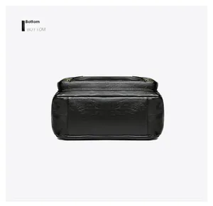Detailed bottom view of the black textured leather handbag with gold metal accents