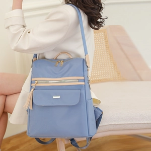 Sac à dos bleu clair contrasté avec pompon et bretelles en nylon réglables sur modèle