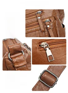 Detailansicht der goldenen Reißverschlüsse und Beschläge auf brauner Lederhandtasche