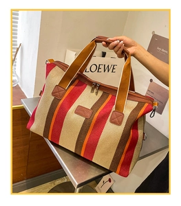 Detail van de geweven kleurrijke gestreepte shopper met lederen logo en ritssluiting