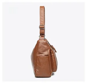 Seitenansicht der braunen Kunstleder-Schultertasche mit Reißverschluss und Gurt