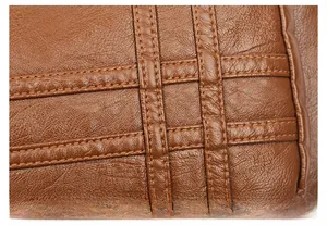 Detail aus braunem Leder mit Lychee-Maserung und präziser Doppelnaht-Verarbeitung