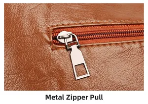 Detail of silver metal zipper puller on high-quality brown lychee textured leather bag
