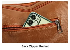 Close-up of the back zipper pocket on brown pebbled leather bag holding a smartphone