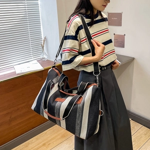 Gestreepte canvas shopper met leren handvatten getoond in een modieuze lifestyle-look