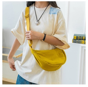 Detail of yellow nylon crescent crossbody bag featuring adjustable wide shoulder strap