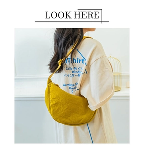 Detail of yellow nylon half-moon crossbody bag with knot shoulder strap on model