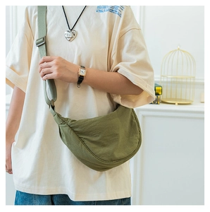 Army green nylon crescent crossbody bag shown on a model with adjustable strap