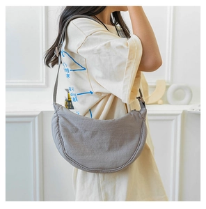 Side view of gray nylon crescent bag showing soft drape and adjustable wide strap