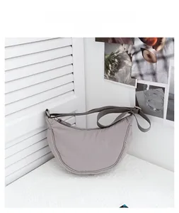 Detail of grey nylon crescent bag showing smooth fabric texture and adjustable strap