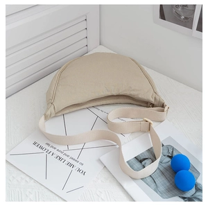 Detail of beige nylon crescent bag with adjustable wide strap and textured fabric finish