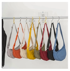 Detailed display of eight colorful crescent nylon crossbody bags hanging on a display rack