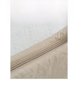 Close-up of smooth khaki nylon fabric and durable zipper detail on the crossbody bag