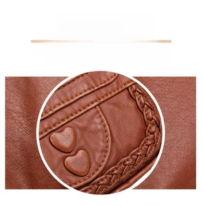 Detail of soft brown pebble leather crossbody bag with heart patches and woven edge trim