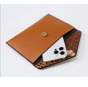Détail de la doublure crocodile marron et de la capacité smartphone d'une pochette