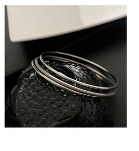 Detailed macro shot of three-piece silver titanium steel bangles with matte and polished texture