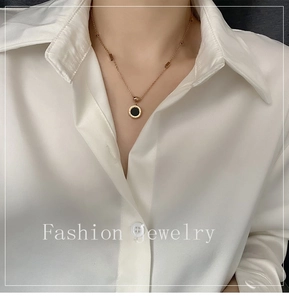 Détail du collier à chiffres romains avec pendentif noir porté sur un mannequin élégant