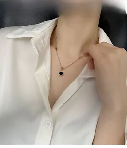 Détail du collier or rose avec chiffres romains et pendentif circulaire noir sur modèle