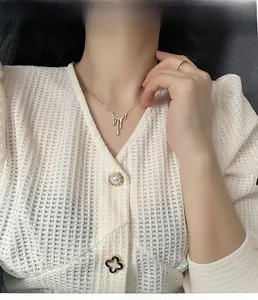 Vue détaillée d'un collier doré avec pendentif goutte de lave liquide sur un mannequin