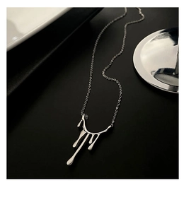 Détail macro du pendentif goutte de lave argentée sur chaîne ras du cou minimaliste