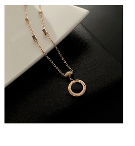 Vue détaillée du collier en or rose avec pendentif chiffres romains et onyx noir poli
