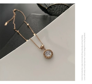 Détail du collier chiffre romain or rose avec pendentif en nacre blanche et chaîne fine