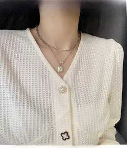 Close-up of double-layer silver necklace with square portrait pendant and white pearl
