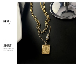 Detail of gold double-layer necklace with square coin pendant and a white pearl