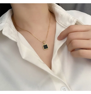 Minimalist black square pendant necklace in titanium steel on a white shirt model