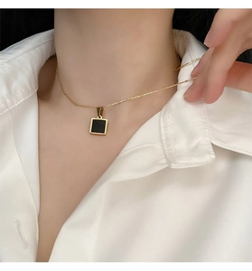Detailed view of a geometric black square pendant on a delicate gold titanium necklace