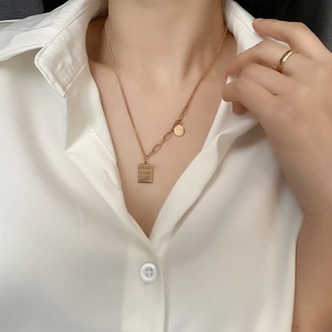 Gold titanium steel necklace with rectangular Good Luck tag shown on female model